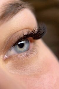 Близький план: око з виразними нарощеними віями та доглянутою бровою, акуратна шкіра навколо.